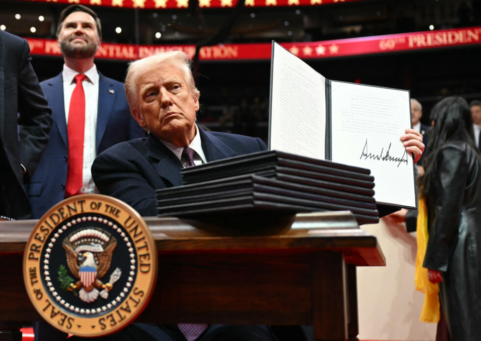 Trump signs a stack of executive order on the evening of his inauguration