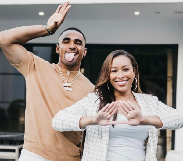 Hurts and Lynn posing doing the Delta Sigma Theta sign and the Omega Psi Phi sign.