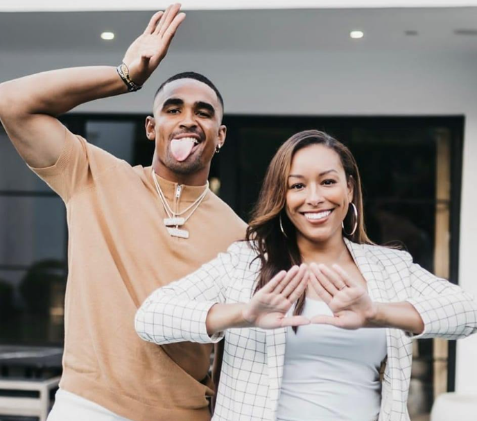 Hurts and Lynn posing doing the Delta Sigma Theta sign and the Omega Psi Phi sign.